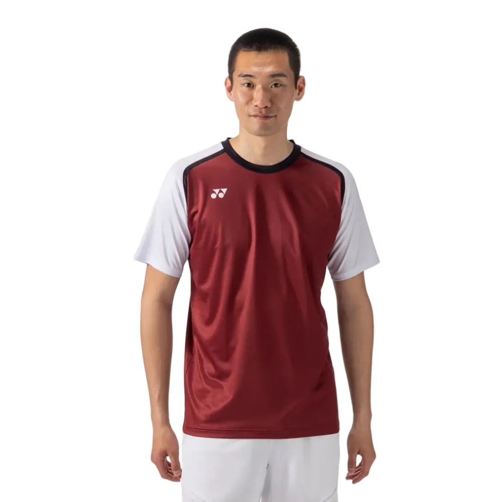 A male model stands against a light gray studio background wearing a short-sleeve athletic jersey and matching shorts. The jersey is burgundy red on the front with white sleeves and black shoulder trim, plus a small white logo on the chest.